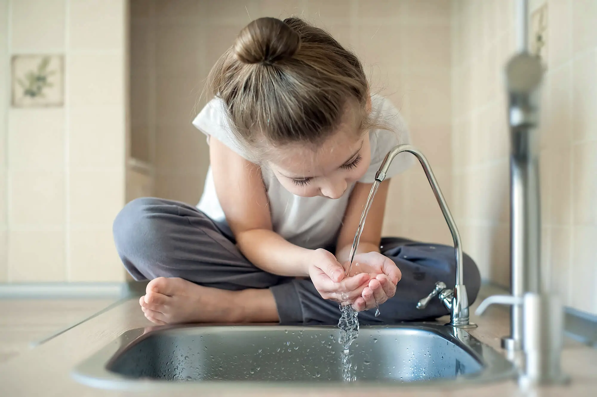 niña bebiendo agua filtrada - osmosis y filtracion